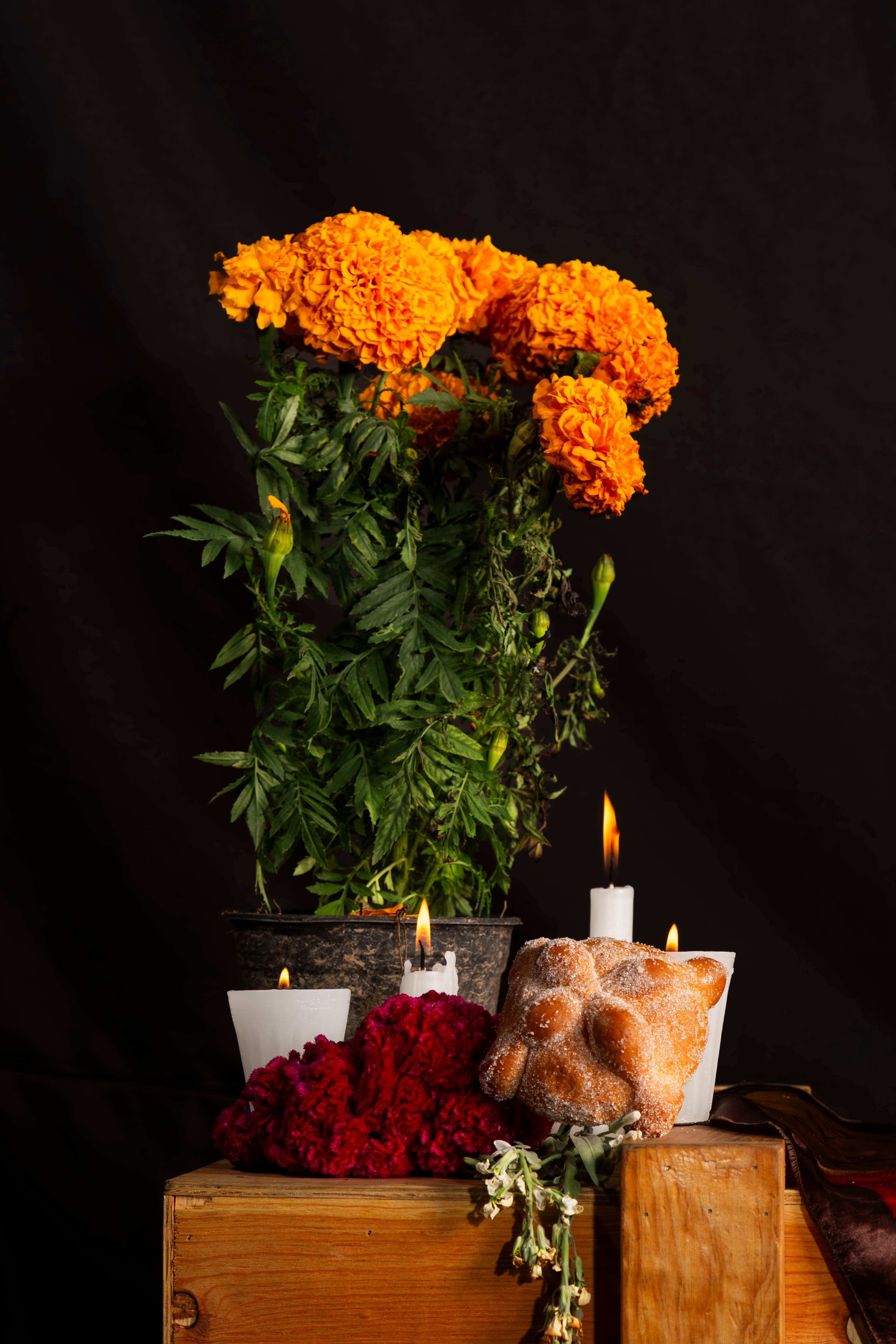 Traditional Día de Muertos altar decorated with marigold flowers, candles, and offerings
